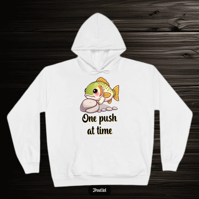 Funny hoodie featuring a determined kawaii trout nudging a pebble, offering cozy comfort with a message of perseverance.