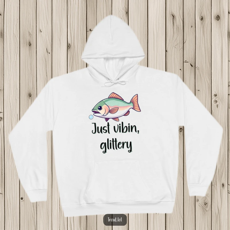 Funny hoodie depicting a trout with glittery scales joyfully chasing a tiny bubble, expressing pure delight.